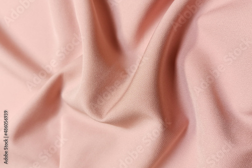 Pink crumpled or wavy fabric texture background. Abstract linen cloth soft waves. Silk atlas or stretch jacquard. Smooth elegant luxury cloth texture. Concept for banner or advertisement.