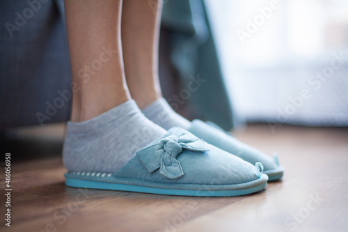 Women's legs in slippers of home turquoise (side view)