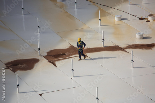 Male worker on white roof of storage crude oil