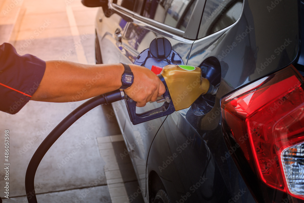 Pumping gas at gas pump. Closeup of man pumping gasoline fuel in car at gas station. Pumping gas at gas pump. Closeup of man pumping gasoline fuel in car at gas station.