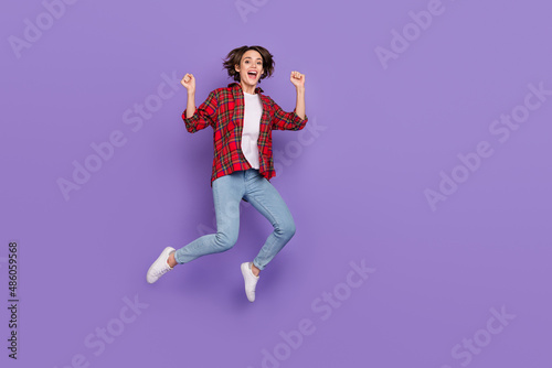 Fototapeta Naklejka Na Ścianę i Meble -  Full size photo of cool millennial brunette lady jump wear shirt jeans shoes isolated on purple background