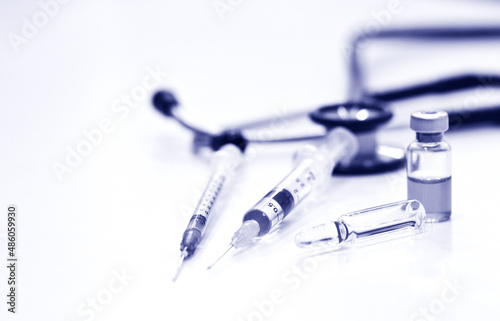 Vial and Ampule of Drug, 1 and 3 ml Plastic Syringe with Needle and Out of Focus of Stethoscope,Isolated on the White Background