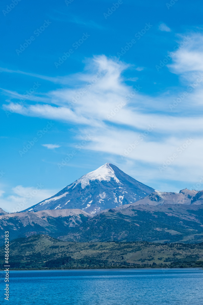 Top of volcano peak mountain with snow under the blue sky with grass field and steppes.
Top of volcano peak mountain with snow under the blue sky with grass field and steppes.
