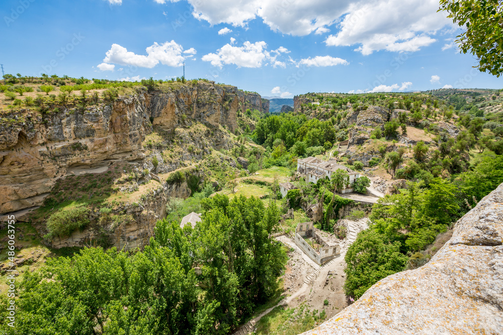 City canyon perspective. Alhama de Granada, Andalusia, Spain. Beautiful and interesting travel destination in the warm Southern region. Public street view.