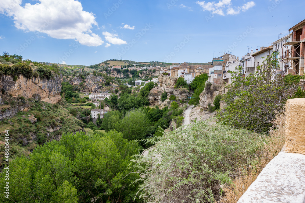City canyon perspective. Alhama de Granada, Andalusia, Spain. Beautiful and interesting travel destination in the warm Southern region. Public street view.
