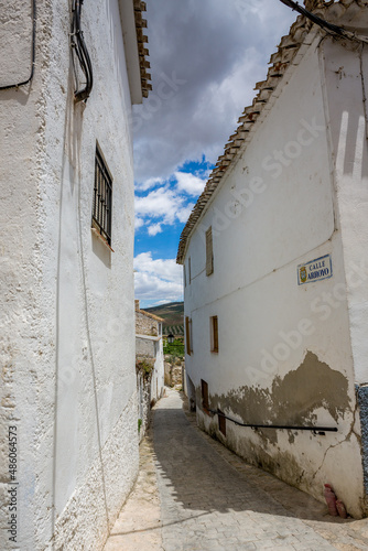 Between whitewashed houses. Alhama de Granada, Andalusia, Spain. Beautiful and interesting travel destination in the warm Southern region. Public street view.