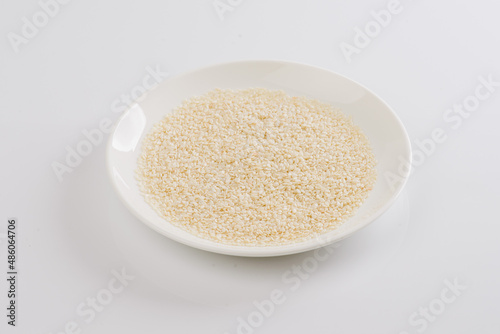 white sesame seeds on a white plate on a white background
