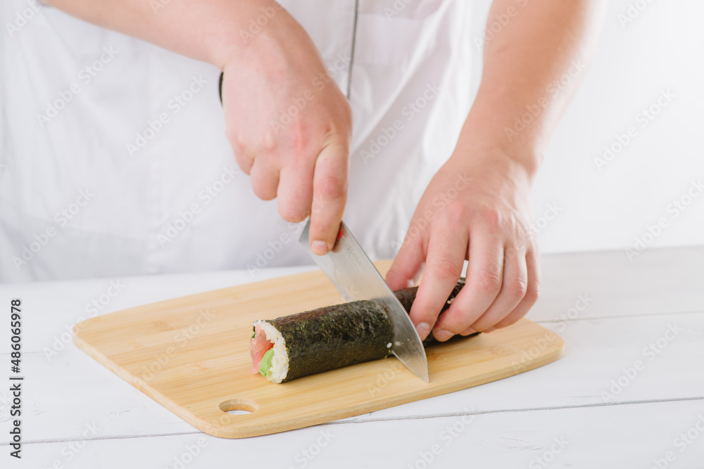 the chef prepares sushi and cuts them with a knife