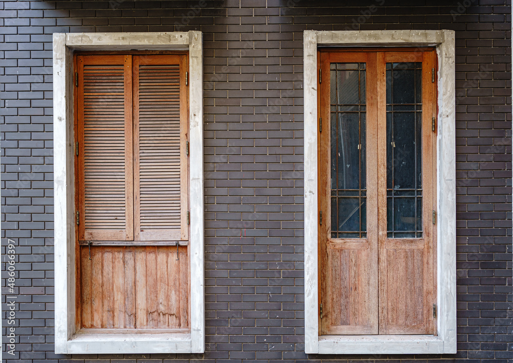 Wooden door and windows on  brick wall.