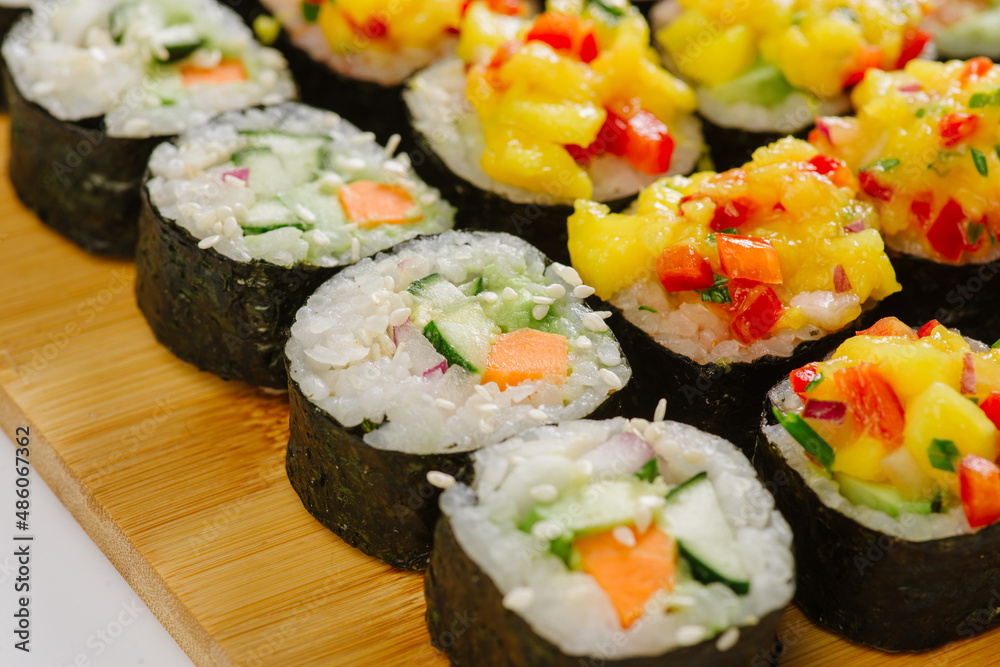 Maki Sushi Rolls set on wooden board. Japanese traditional Cuisine. White background. Maki Sushi Rolls set on wooden board. Japanese traditional Cuisine. White background.