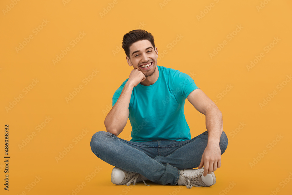 Young caucasian man on orange background in studio Young caucasian man on orange background in studio