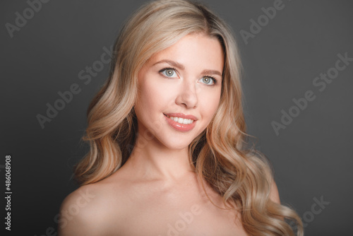 Close-up portrait of a beautiful young blonde woman with luxurious hair.