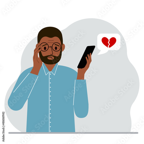 Sad man reading a message on his mobile phone. Message with a broken red heart. Vector