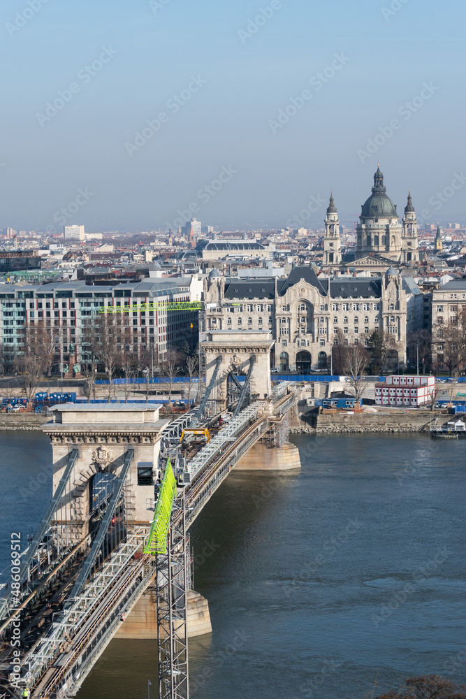 Szechenyi chain bridge over Danube river under renovation and Saint Stephen's Basilica in Budapest, Hungary
