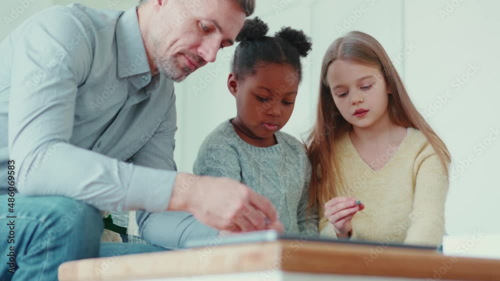 Concentrated multinational family collects puzzles at home Concentrated multinational family collects puzzles at home