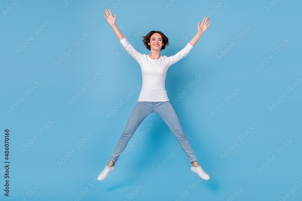 Full size photo of excited crazy cheerful girl jumping in star pose fooling around isolated on blue color background