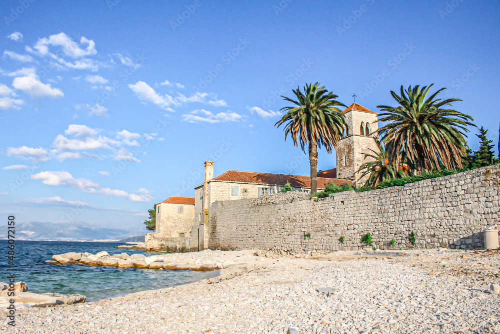 Fototapeta premium Beautiful resort along Dalmatian Coast,Trogir, Croatia. Sunny promenade along the pier of old Venetian town, Dalmatian Coast in Croatia.