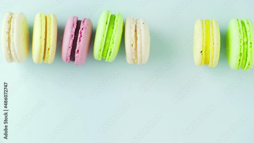 Top view of multicolored French Macarons cookies on a pastel blue background Top view of multicolored French Macarons cookies on a pastel blue background