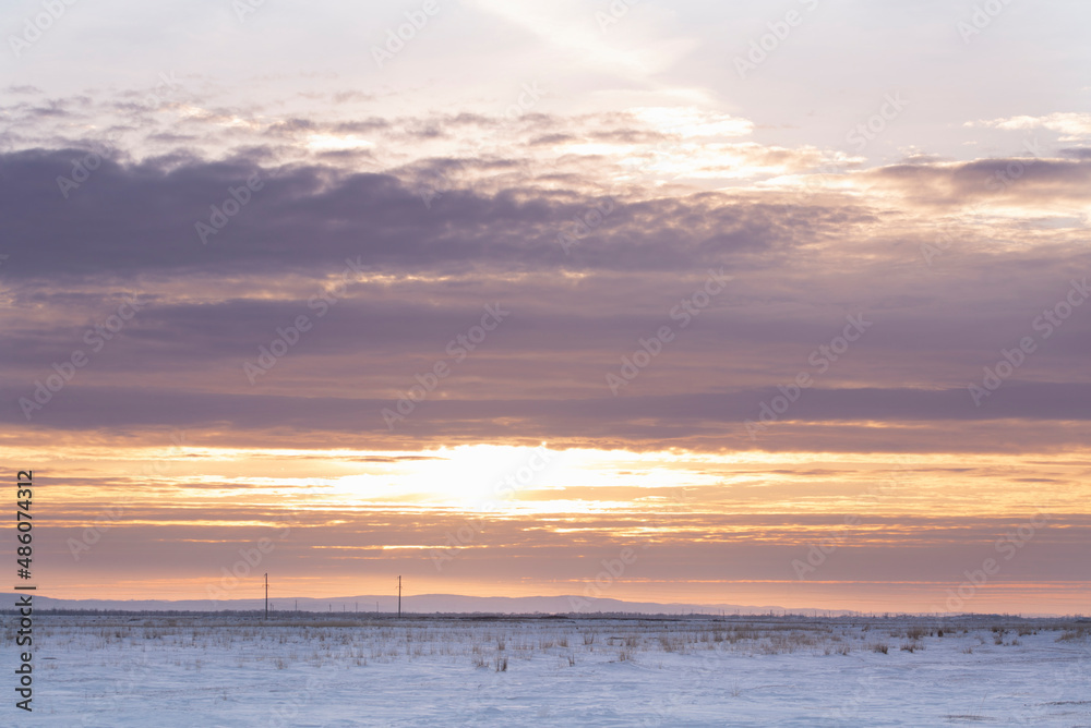 A snowy field at sunset.Winter steppe landscape. The concept of nature A snowy field at sunset.Winter steppe landscape. The concept of nature
