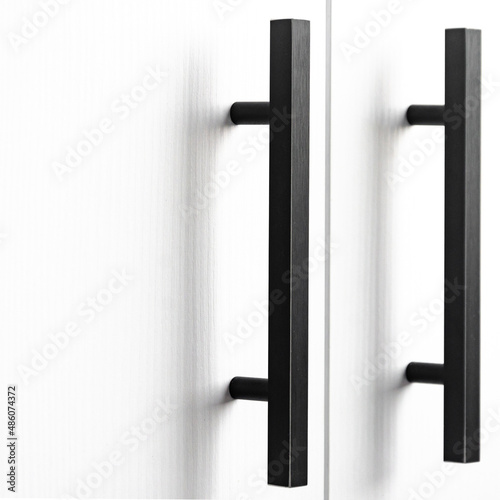 white wood cupboard door by black handle. Modern kitchen furniture concept. Cozy apartment details