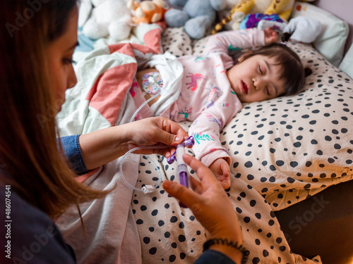 Quadro su tela Mother caring for daughter with feeding tube
