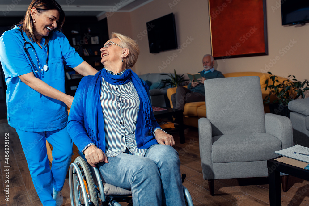 Obraz premium Female nurse assisting senior woman in a wheelchair at nursing home.