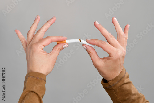 Close-up of a female hand breaking cigarette  photo