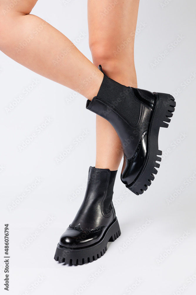 New collection of women's shoes spring 2022. girl's legs in new shoes. Legs in black boots. Low running boots made of genuine leather New collection of women's shoes spring 2022. girl's legs in new shoes. Legs in black boots. Low running boots made of genuine leather