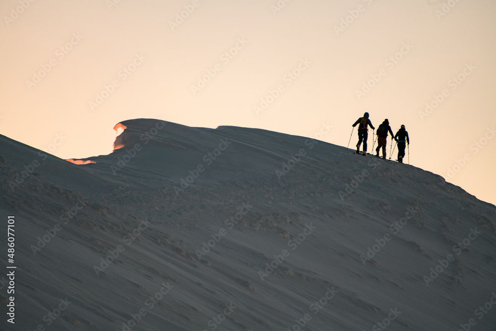 snow-covered mountain slope with walking skiers on it. Ski touring and freeride concept