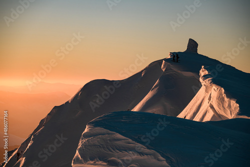 beautiful view of picturesque landscape and snow-covered mountain top and skiers on it. Ski touring concept