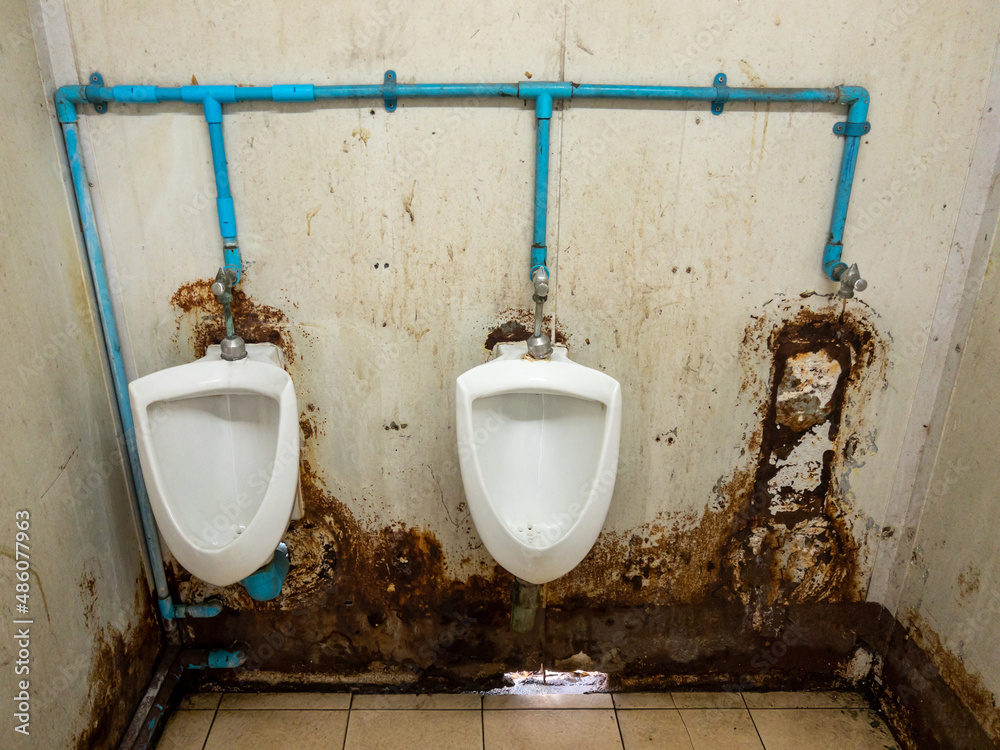The dirty urinal row of the temporary toilet in the railway station