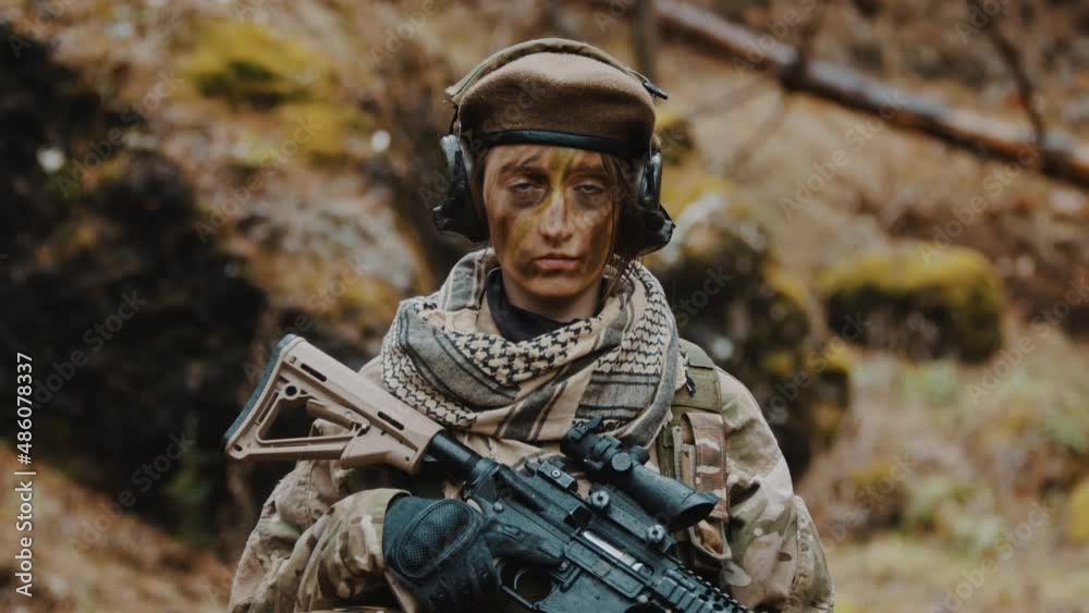 armed female soldier holding an automatic rifle portrait looking to the ...