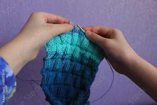 Foto The canvas is knitted from melange yarn with knitting needles