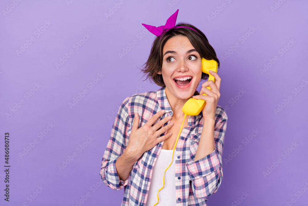 Photo of excited funny woman wear plaid shirt talking phone looking empty space isolated violet color background Photo of excited funny woman wear plaid shirt talking phone looking empty space isolated violet color background