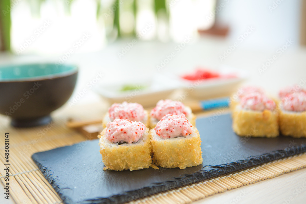 Maki roll with salmon, popular Japanese cuisine. Sushi roll with fish, cream cheese and vegetables