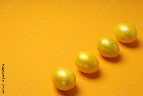 Easter eggs on orange background, space for text
