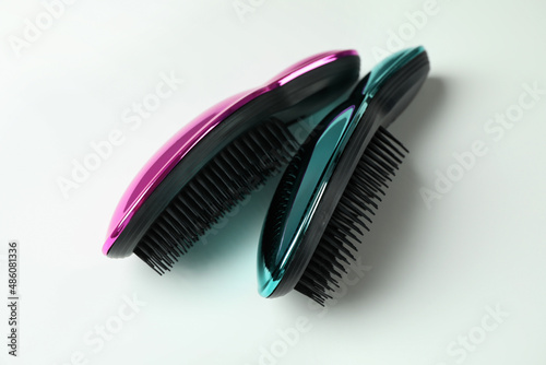 Colored plastic hair brushes on white background