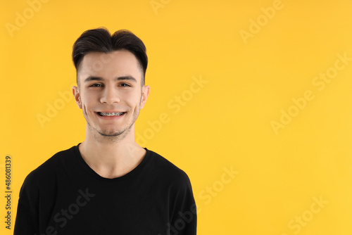 Attractive young man in t-shirt on yellow background © Atlas