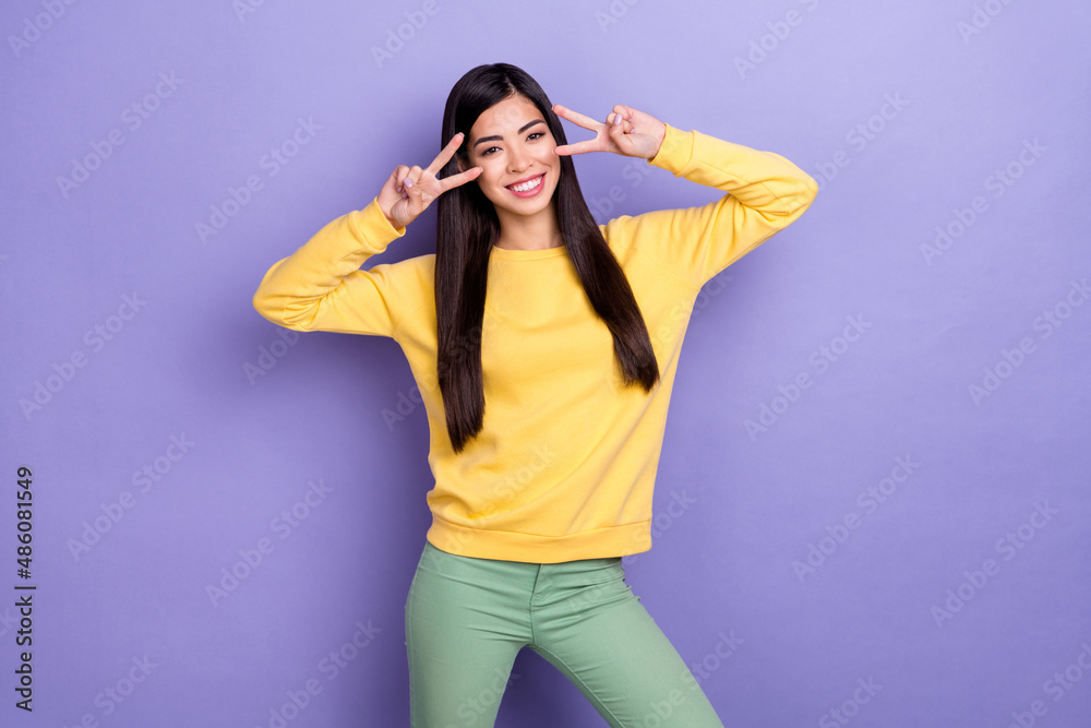 Photo of cute good mood positive young lady showing v-sign on eyes meet friends isolated on purple color background Photo of cute good mood positive young lady showing v-sign on eyes meet friends isolated on purple color background