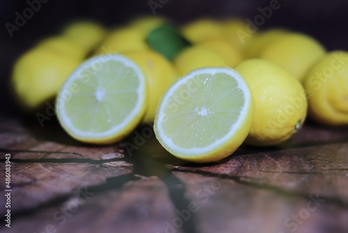 Limón partido sobre madera y limones en el fondo