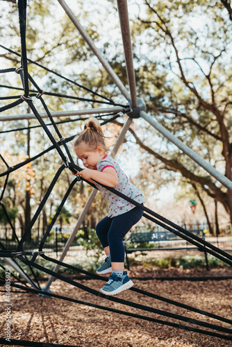 Child at playground. Little girl on a playground climbing net tower. Outdoor play space on Polyester Twisted Rope. Playground Climbing Rope Tower 