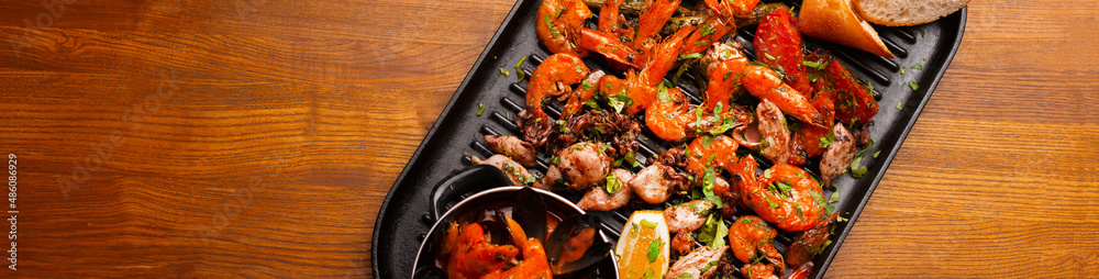 Top view photo of big pan with grilled sea food, mussels shrimps and others. Top view photo of big pan with grilled sea food, mussels shrimps and others.