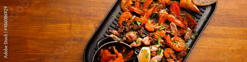 Top view photo of big pan with grilled sea food, mussels shrimps and others.