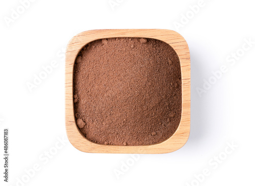 Closeup cocoa powder in wooden bowl isolated on white background with clipping path. Top view. Flat lay.