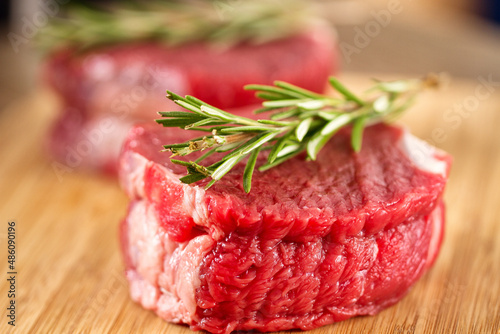 Raw Beef Tenderloin with Rosemary on a Cutting Board