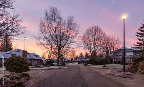 View of Residential Suburban Neighborhood Street in a modern city. Frosty Cloudy Winter Morning Sunrise Sky. Fraser Heights, Surrey, Vancouver, British Columbia, Canada.