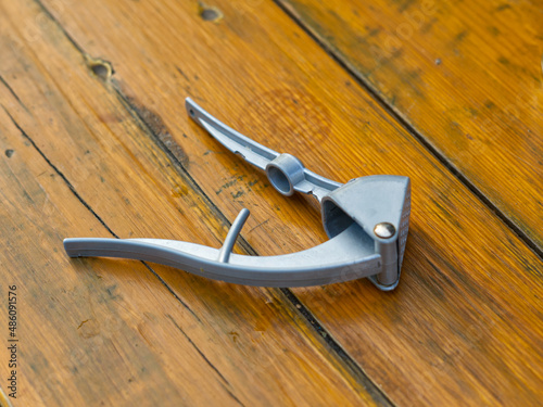 The nut and garlic presser is manual closeup. Devices for cooking. Against the background of a wooden table