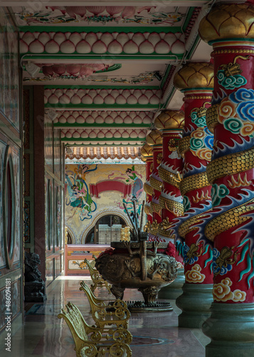 The magnificent of Chinese-style temple corridor with sculptured dragons pillars, Large incense burner decorated with dragon pattern and has Gold metal benchs for relaxation. Wihan Thep Sathit Phra