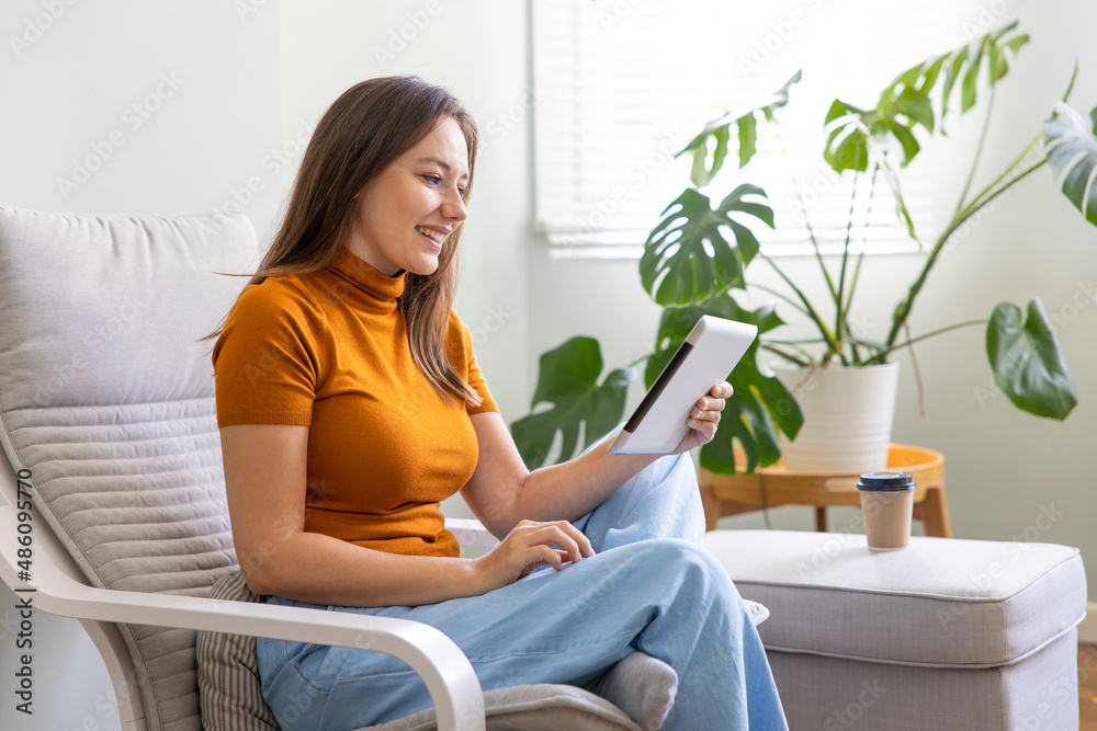 Young woman using digital tablet at home. Young woman using digital tablet at home.
