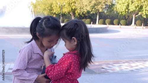 Slow motion scene of  6-year-old Asian girl shares water with friends to eat, dispensation, share 